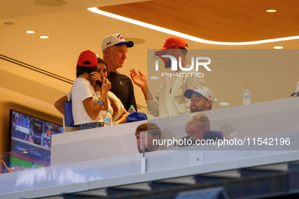 NBA star Stephen Curry stands in the owner's box chatting with former NBA star Chris Mullin during the baseball game against the Boston Red...