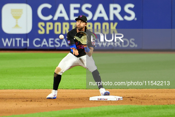 New York Mets second baseman Jeff McNeil takes the throw from third base and relays to first base for the double play during the fifth innin...