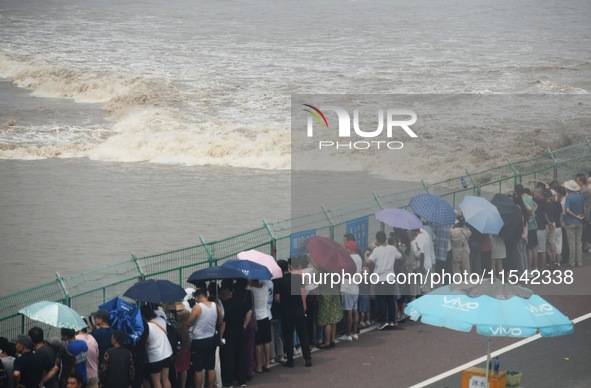 Tourists watch the spring tide of the Qiantang River along the river in Hangzhou, Zhejiang province, China, on September 3, 2024. 