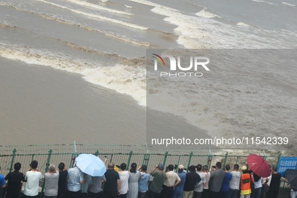 Tourists watch the spring tide of the Qiantang River along the river in Hangzhou, Zhejiang province, China, on September 3, 2024. 