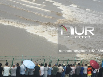 Tourists watch the spring tide of the Qiantang River along the river in Hangzhou, Zhejiang province, China, on September 3, 2024. (