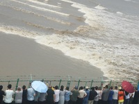 Tourists watch the spring tide of the Qiantang River along the river in Hangzhou, Zhejiang province, China, on September 3, 2024. (