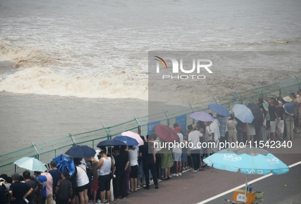 Tourists watch the spring tide of the Qiantang River along the river in Hangzhou, Zhejiang province, China, on September 3, 2024. 