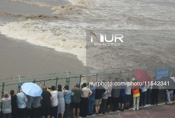 Tourists watch the spring tide of the Qiantang River along the river in Hangzhou, Zhejiang province, China, on September 3, 2024. 