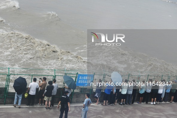 Tourists watch the spring tide of the Qiantang River along the river in Hangzhou, Zhejiang province, China, on September 3, 2024. 