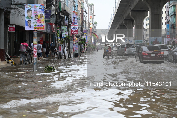 Vehicles and rickshaws attempt to navigate the waterlogged streets of Dhaka with passengers on September 3, 2024, after heavy monsoon rains...