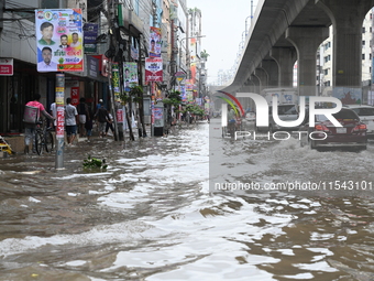 Vehicles and rickshaws attempt to navigate the waterlogged streets of Dhaka with passengers on September 3, 2024, after heavy monsoon rains...