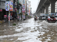 Vehicles and rickshaws attempt to navigate the waterlogged streets of Dhaka with passengers on September 3, 2024, after heavy monsoon rains...