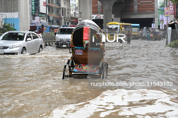 Vehicles and rickshaws attempt to navigate the waterlogged streets of Dhaka with passengers on September 3, 2024, after heavy monsoon rains...