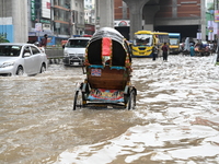 Vehicles and rickshaws attempt to navigate the waterlogged streets of Dhaka with passengers on September 3, 2024, after heavy monsoon rains...