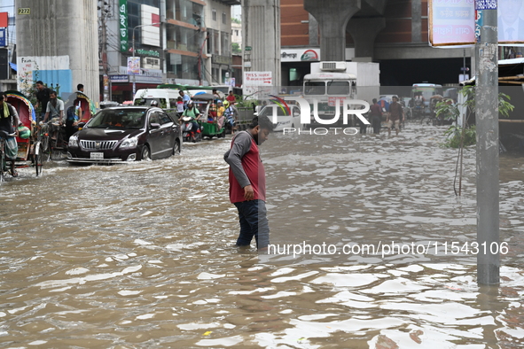 Vehicles and rickshaws attempt to navigate the waterlogged streets of Dhaka with passengers on September 3, 2024, after heavy monsoon rains...