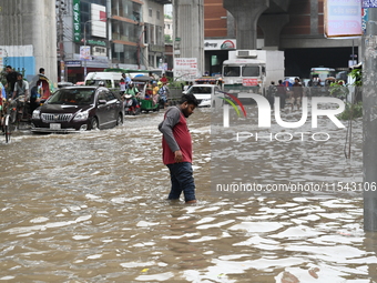 Vehicles and rickshaws attempt to navigate the waterlogged streets of Dhaka with passengers on September 3, 2024, after heavy monsoon rains...