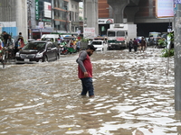 Vehicles and rickshaws attempt to navigate the waterlogged streets of Dhaka with passengers on September 3, 2024, after heavy monsoon rains...