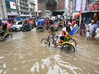 Vehicles and rickshaws attempt to navigate the waterlogged streets of Dhaka with passengers on September 3, 2024, after heavy monsoon rains...