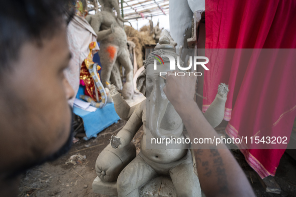 Artisans work on idols of the elephant-headed Hindu deity Ganesha at a workshop ahead of the Ganesh Chaturthi festival in Guwahati, Assam, I...