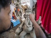 Artisans work on idols of the elephant-headed Hindu deity Ganesha at a workshop ahead of the Ganesh Chaturthi festival in Guwahati, Assam, I...