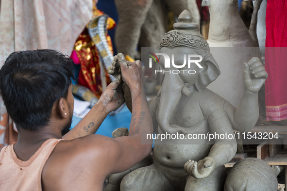 Artisans work on idols of the elephant-headed Hindu deity Ganesha at a workshop ahead of the Ganesh Chaturthi festival in Guwahati, Assam, I...