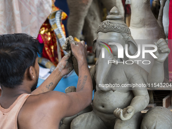 Artisans work on idols of the elephant-headed Hindu deity Ganesha at a workshop ahead of the Ganesh Chaturthi festival in Guwahati, Assam, I...