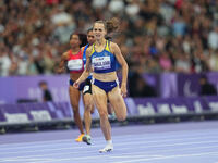 Yuliia Shuliar of Ukraine celebrates winning gold in Women's 400m - T20 Final during the Paris 2024 Paralympic Games at Stade de France on S...