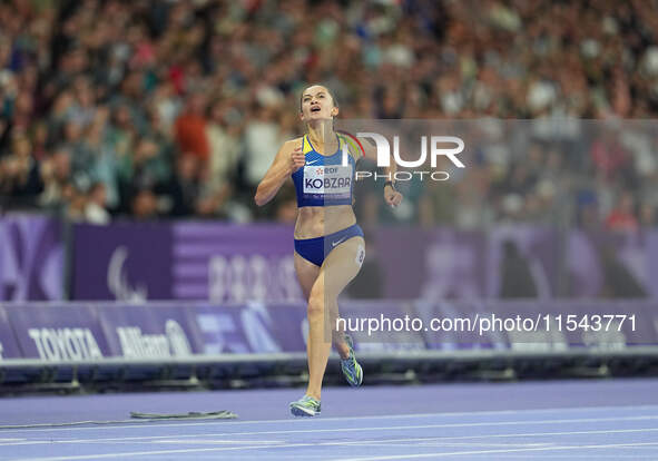 Nataliia Kobzar of Ukraine celebrates winning gold in Women's 400m - T37 Final during the Paris 2024 Paralympic Games at Stade de France on...