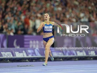 Nataliia Kobzar of Ukraine celebrates winning gold in Women's 400m - T37 Final during the Paris 2024 Paralympic Games at Stade de France on...