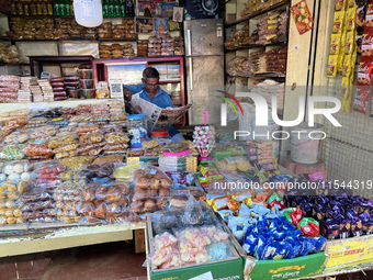 A shopkeeper reads a newspaper at the Connemara market (Palayam Market) in Thiruvananthapuram, Kerala, India, on April 13, 2024. The Connema...