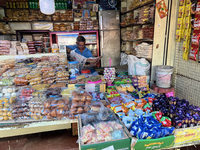 A shopkeeper reads a newspaper at the Connemara market (Palayam Market) in Thiruvananthapuram, Kerala, India, on April 13, 2024. The Connema...