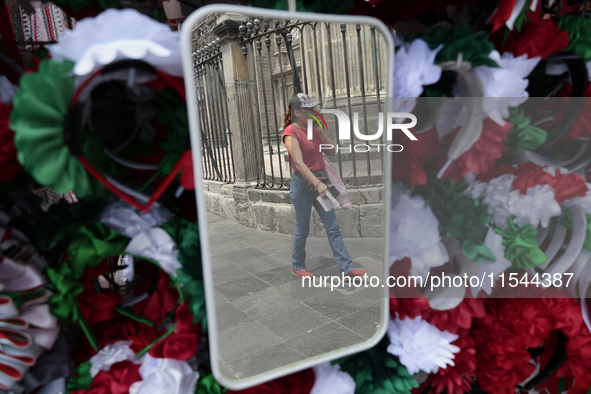 A woman reflects in a mirror in the Zocalo of Mexico City, Mexico, on September 3, 2024, on the eve of the Grito de Independencia of Mexico...