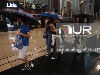 Passersby walk in the rain on Madero Avenue in Mexico City, Mexico, on September 3, 2024, on the eve of Mexican Independence Day on Septembe...