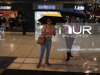 Passersby walk in the rain on Madero Avenue in Mexico City, Mexico, on September 3, 2024, on the eve of Mexican Independence Day on Septembe...