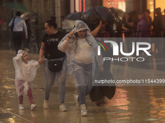 Passersby walk in the rain on Madero Avenue in Mexico City, Mexico, on September 3, 2024, on the eve of Mexican Independence Day on Septembe...