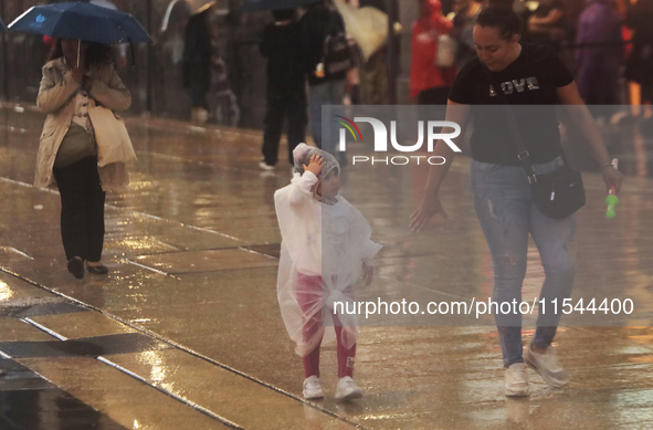 Passersby walk in the rain on Madero Avenue in Mexico City, Mexico, on September 3, 2024, on the eve of Mexican Independence Day on Septembe...