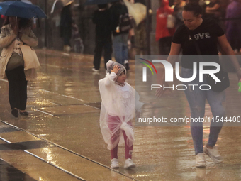 Passersby walk in the rain on Madero Avenue in Mexico City, Mexico, on September 3, 2024, on the eve of Mexican Independence Day on Septembe...