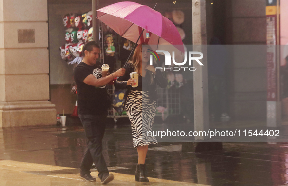 Passersby walk in the rain on Madero Avenue in Mexico City, Mexico, on September 3, 2024, on the eve of Mexican Independence Day on Septembe...