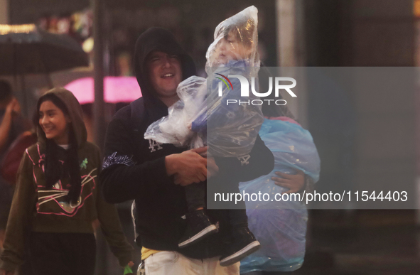 Passersby walk in the rain on Madero Avenue in Mexico City, Mexico, on September 3, 2024, on the eve of Mexican Independence Day on Septembe...