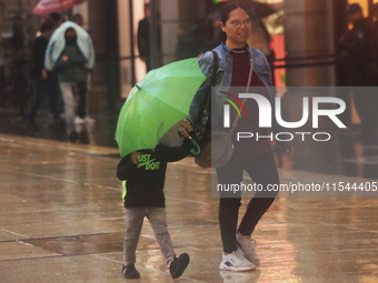 Passersby walk in the rain on Madero Avenue in Mexico City, Mexico, on September 3, 2024, on the eve of Mexican Independence Day on Septembe...