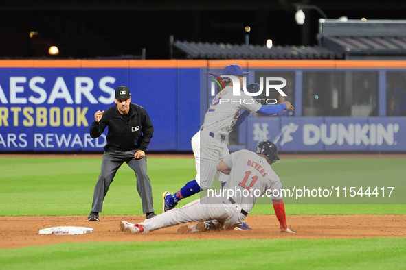 New York Mets shortstop Francisco Lindor #12 leaps over Boston Red Sox Rafael Devers #11 for the double play during the baseball game agains...