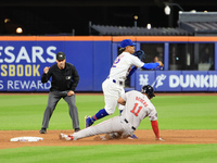 New York Mets shortstop Francisco Lindor #12 leaps over Boston Red Sox Rafael Devers #11 for the double play during the baseball game agains...