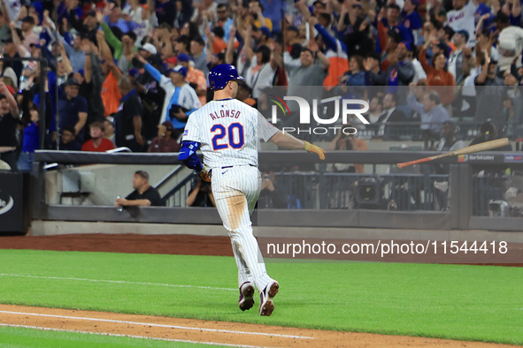 Pete Alonso #20 of the New York Mets tosses his bat after homering during the eighth inning of the baseball game against the Boston Red Sox...