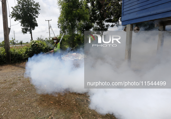 A health worker fumigates to prevent the spread of Dengue fever at a village in Nakhon Sawan province, north of Bangkok, on September 4, 202...