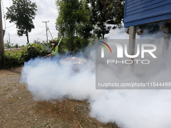 A health worker fumigates to prevent the spread of Dengue fever at a village in Nakhon Sawan province, north of Bangkok, on September 4, 202...