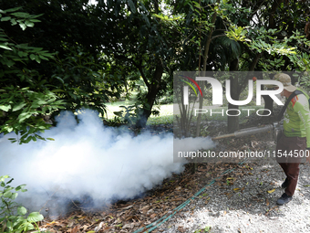 A health worker fumigates to prevent the spread of Dengue fever at a village in Nakhon Sawan province, north of Bangkok, on September 4, 202...