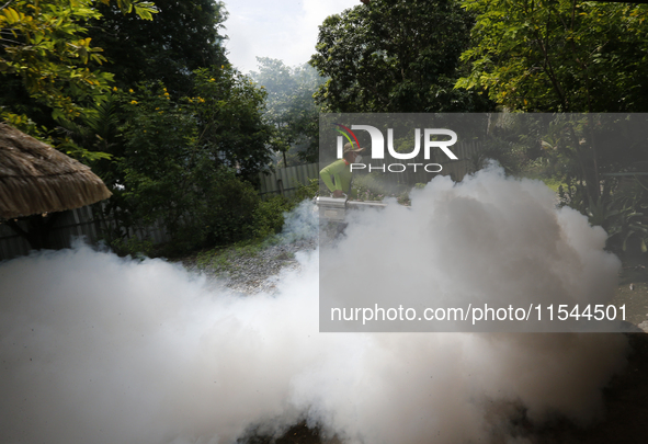 A health worker fumigates to prevent the spread of Dengue fever at a village in Nakhon Sawan province, north of Bangkok, on September 4, 202...