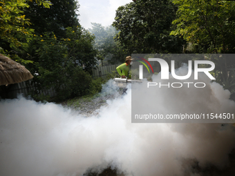 A health worker fumigates to prevent the spread of Dengue fever at a village in Nakhon Sawan province, north of Bangkok, on September 4, 202...