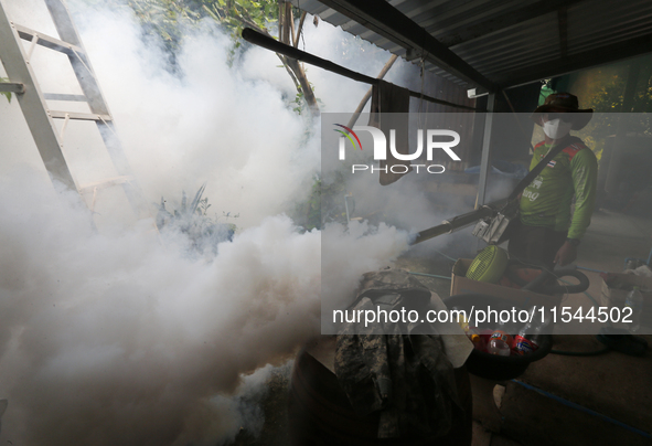 A health worker fumigates to prevent the spread of Dengue fever at a village in Nakhon Sawan province, north of Bangkok, on September 4, 202...