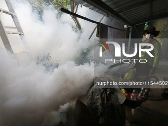 A health worker fumigates to prevent the spread of Dengue fever at a village in Nakhon Sawan province, north of Bangkok, on September 4, 202...