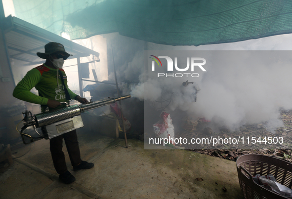 A health worker fumigates to prevent the spread of Dengue fever at a village in Nakhon Sawan province, north of Bangkok, on September 4, 202...