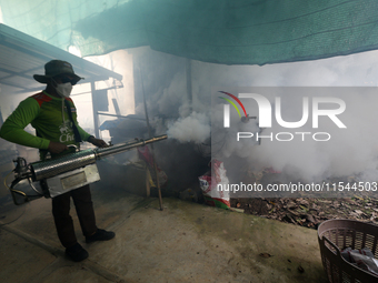 A health worker fumigates to prevent the spread of Dengue fever at a village in Nakhon Sawan province, north of Bangkok, on September 4, 202...