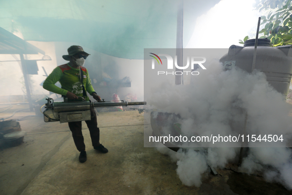 A health worker fumigates to prevent the spread of Dengue fever at a village in Nakhon Sawan province, north of Bangkok, on September 4, 202...