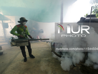 A health worker fumigates to prevent the spread of Dengue fever at a village in Nakhon Sawan province, north of Bangkok, on September 4, 202...